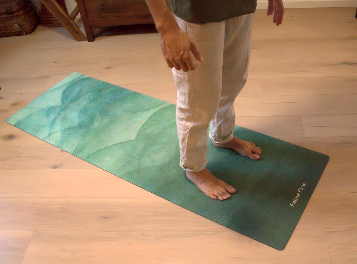 male standing on green yoga mat in a living room with wooden floors