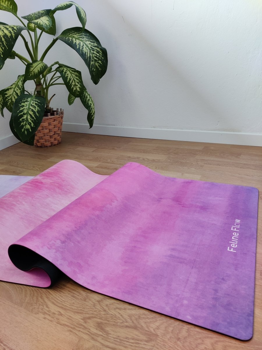 detail of fuchsia yoga mat on wooden floor near indoor plant