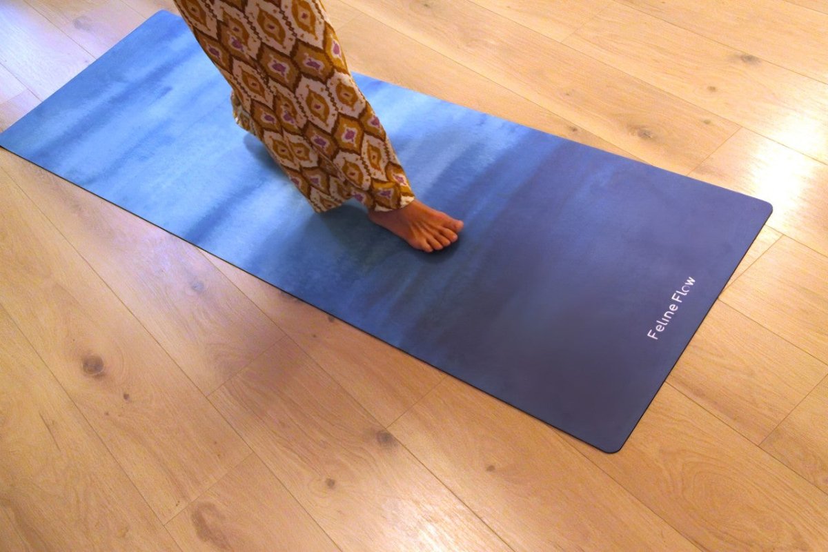 female walking on blue yoga mat in a living room with wooden floors